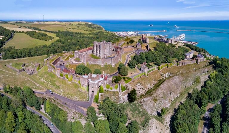 Dover Castle: A panoramic aerial view of Dover Castle, showing the vast fortress on the White Cliffs of Dover overlooking the English Channel and the town below.